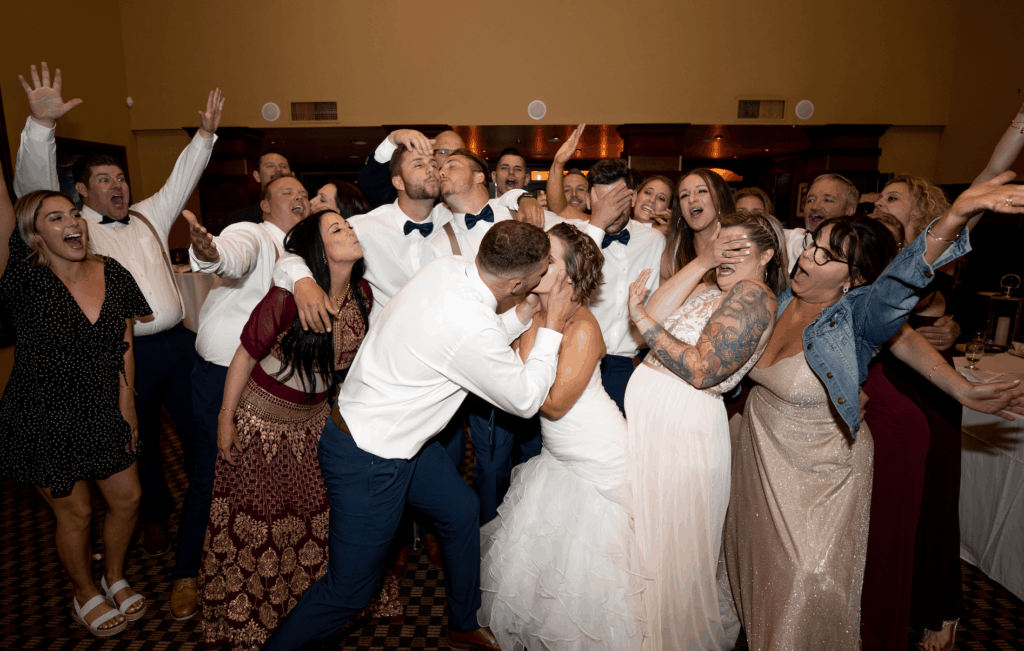A group of people crowded around the bride and groom.